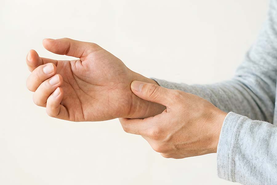 手首の痛みや関節の違和感を訴える男性の手元